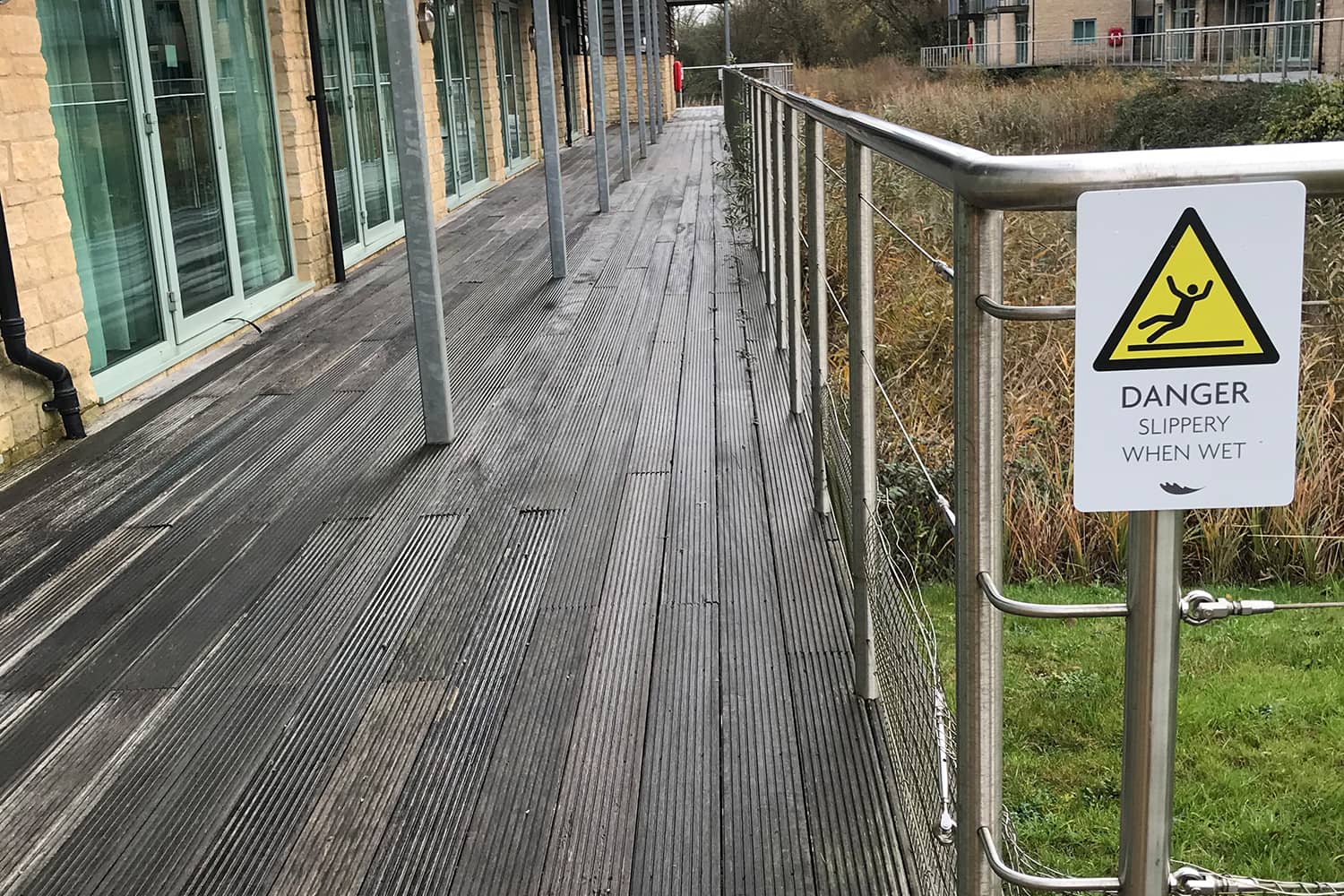 Danger sign next to slippery timber decking on hotel grounds